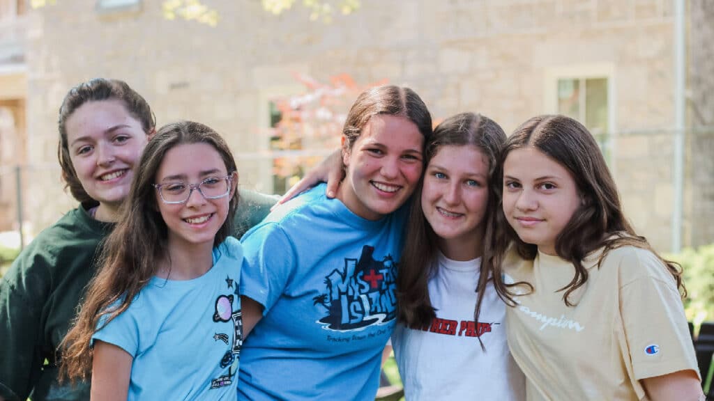 Group of girls at camp smiling for a picture.