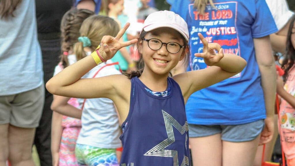 Camper giving the peace sign in a large group.